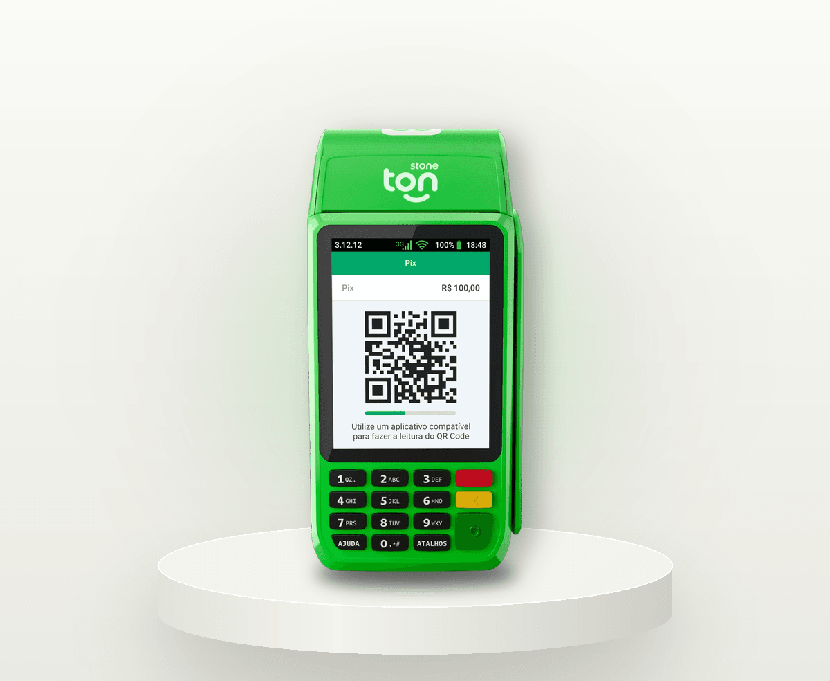 Maquininha Ton T3 verde, de frente, com impressora no topo e tela mostrando um QR Code Pix